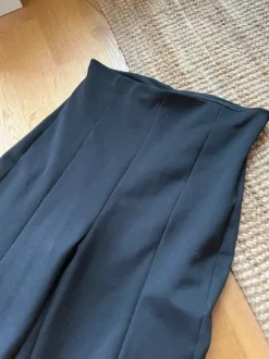 Svarta byxor med veckade detaljer